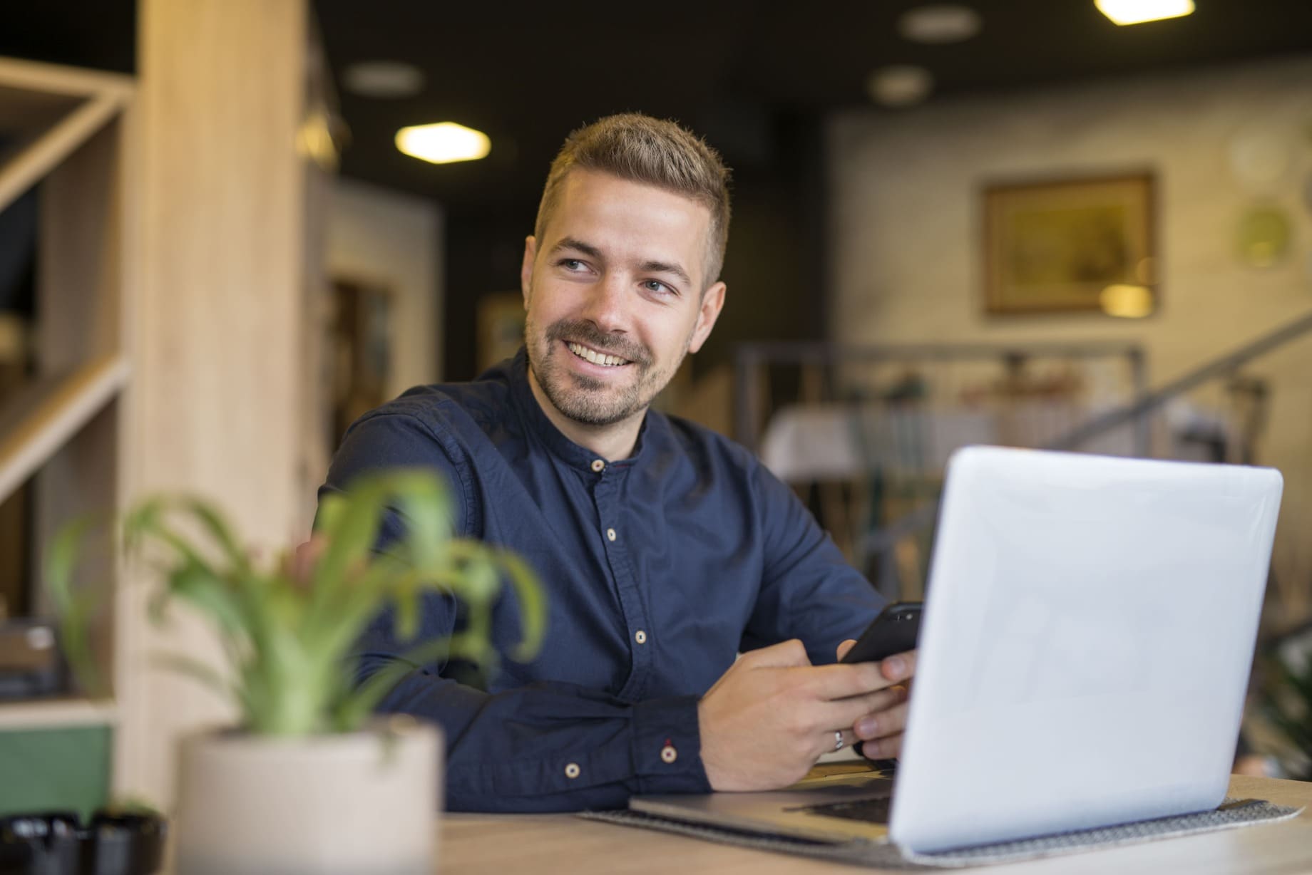 young-businessman-sitting-cozy-cafe-bar-using-laptop-computer-looking-aside