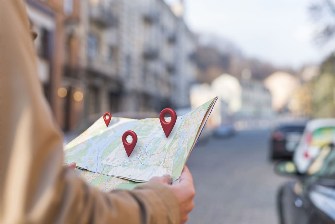 Man-staat-met-fysieke-Google-Maps-kaart-locaties-te-kijken-van-Bedrijfsprofiel