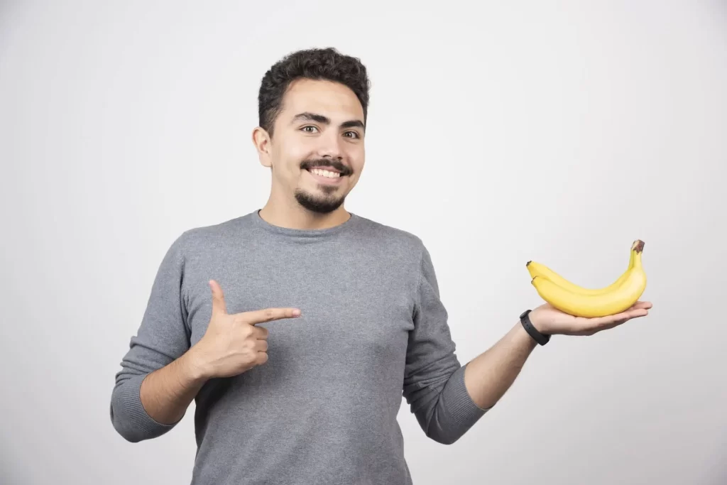 man wijst naar bananen