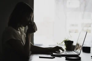 Vrouw achter laptop drinkt een kop thee en kijkt wat er mis is met haar website content